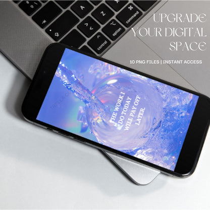 A smartphone screen on laptop displaying a motivational wallpaper with water splashing.